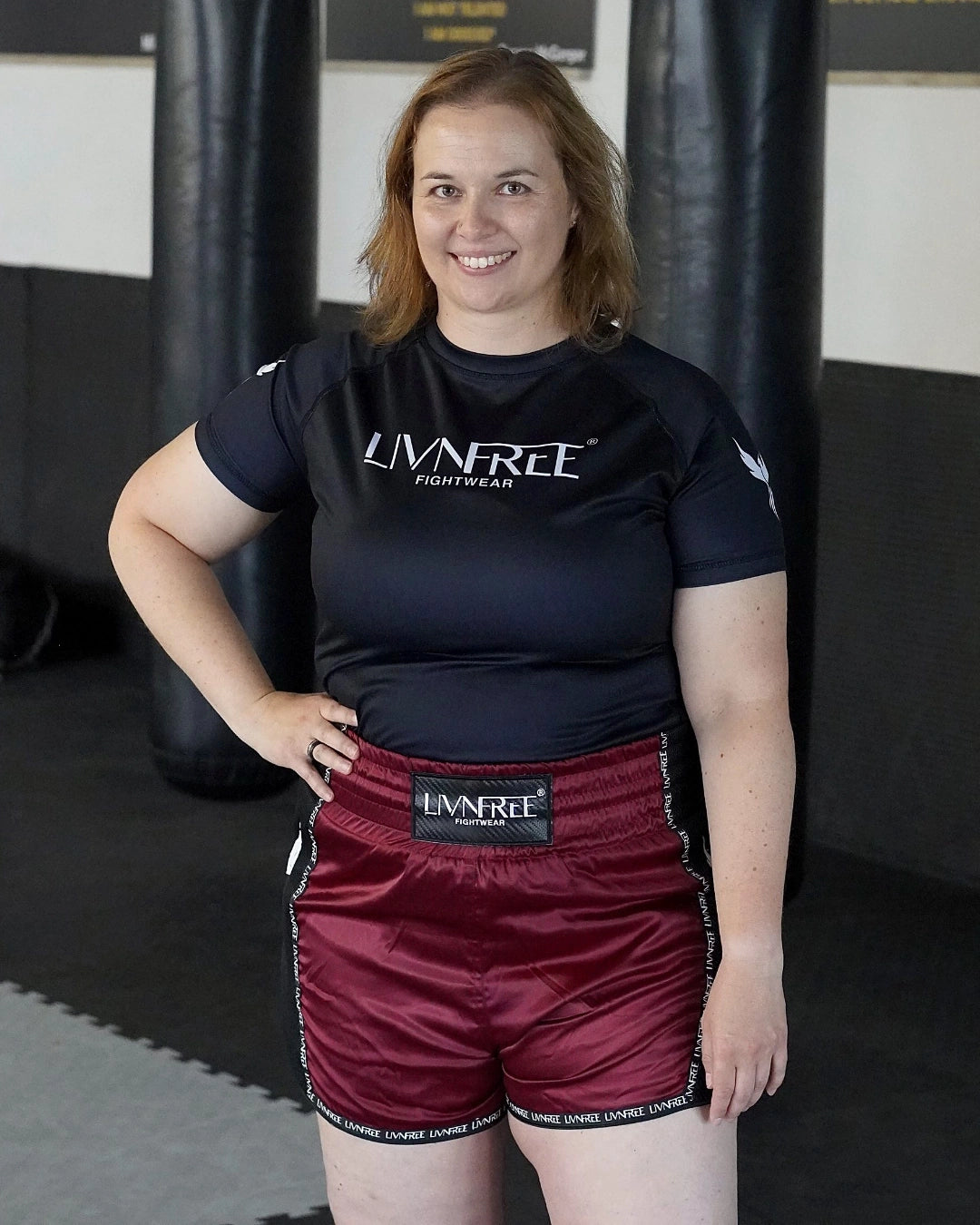 Muay Thai Shorts Burgunda mit schwarzem Bund, Vorderansicht an lächelndem Modell