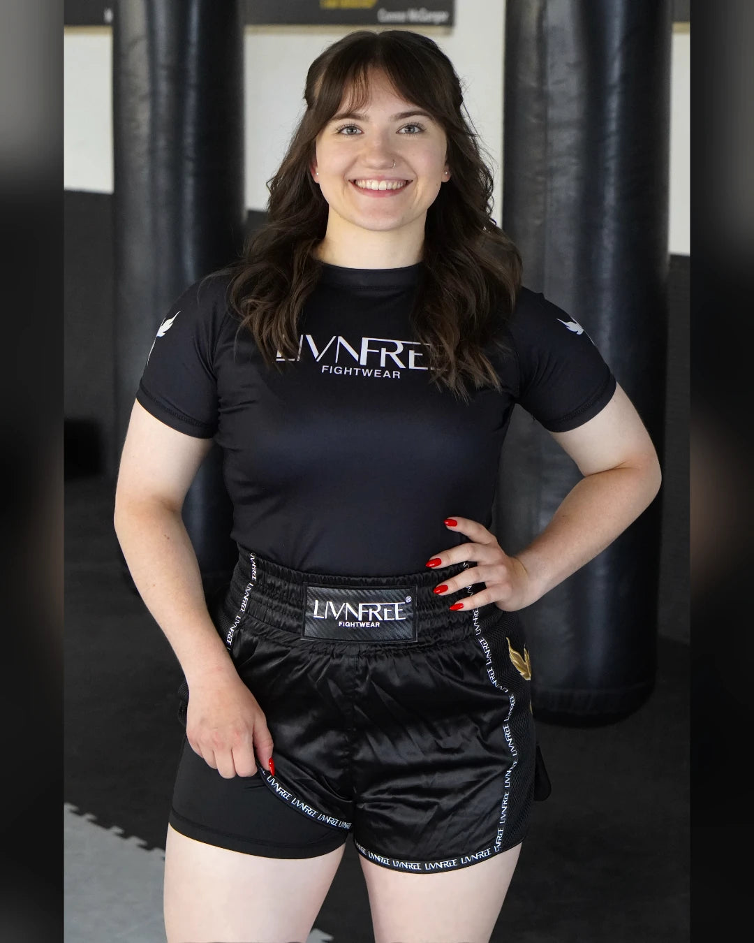 2-in-1 Muay Thai Shorts Damen in Schwarz-Gold, Vorderansicht an Modell im Gym