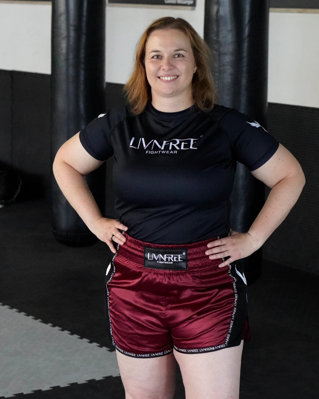 2-in-1 Muay Thai Shorts Burgunda mit breietm Bund, Vorderansicht an lächelndem Modell